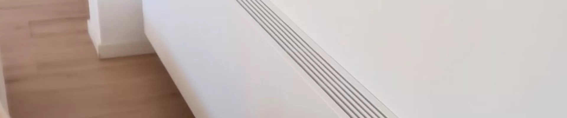 Heizung im Sommer: Flur mit flachem Heizkörper entlang der Wand