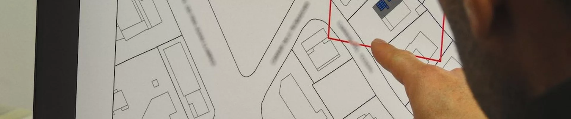 Planer zeigt auf einen Bildschirm mit technischen Zeichnungen Planer zeigt auf einen Bildschirm mit technischen Zeichnungen