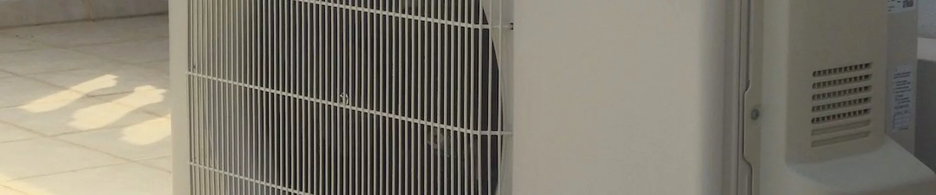 Klimaanlage mit Photovoltaik: Klimaanlagen-Außengerät auf einer Terrasse mit Balustrade Klimaanlage mit Photovoltaik: Klimaanlagen-Außengerät auf einer Terrasse mit Balustrade