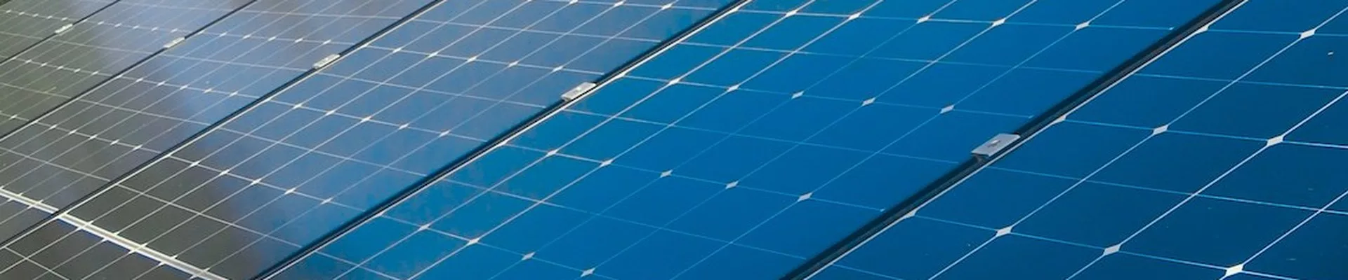Solarmodule auf einem Ziegeldach vor blauem Himmel Solarmodule auf einem Ziegeldach vor blauem Himmel