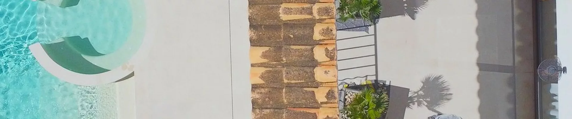 Luftaufnahme von Solarpanels neben einem Pool mit Liegen