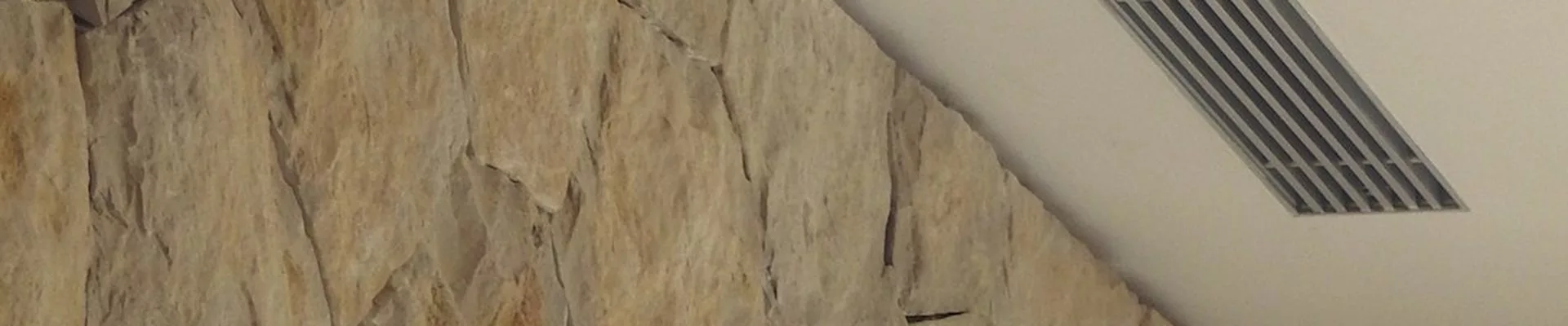 Linear air diffuser next to a natural stone wall Linear air diffuser next to a natural stone wall